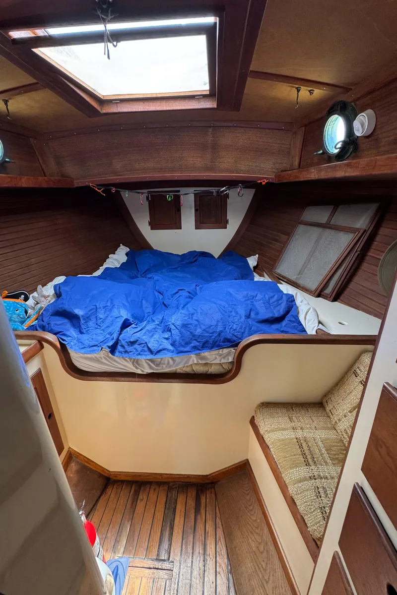 Slide: The Image of Cozy cabin interior of 1985 Bluewater Ingrid 38 sailboat with wooden accents and blue bedding. - 43