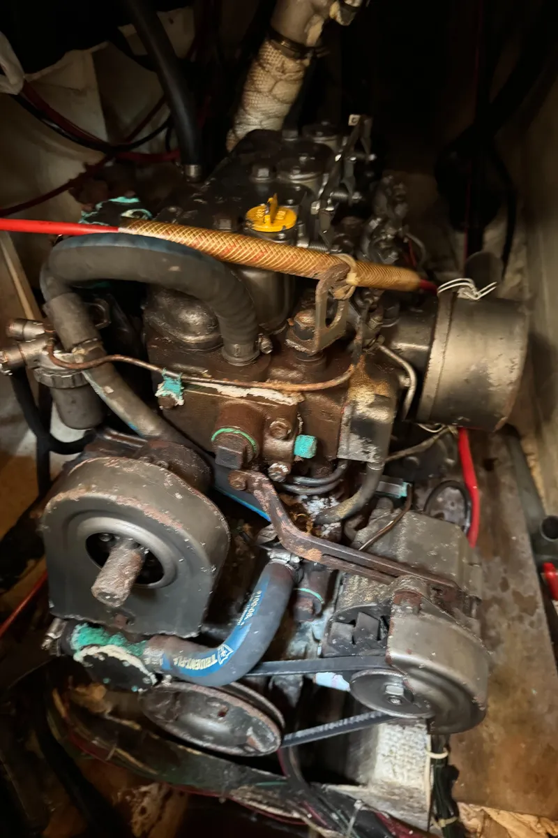 Slide: The Image of Engine compartment of a 1985 Bluewater Ingrid 38 sailboat, showing mechanical components and hoses. - 44