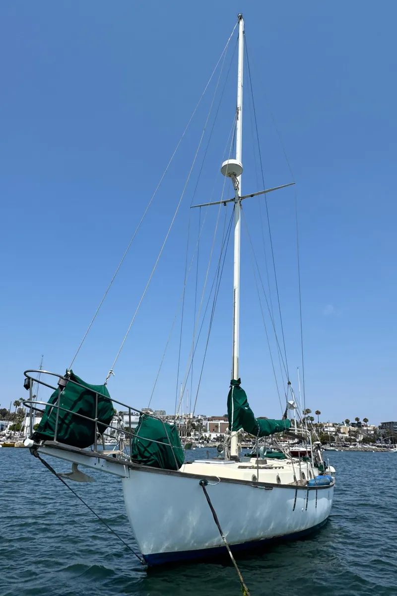 Slide: The Image of 1985 Bluewater Ingrid 38 sailboat on calm water under clear blue sky. - 6