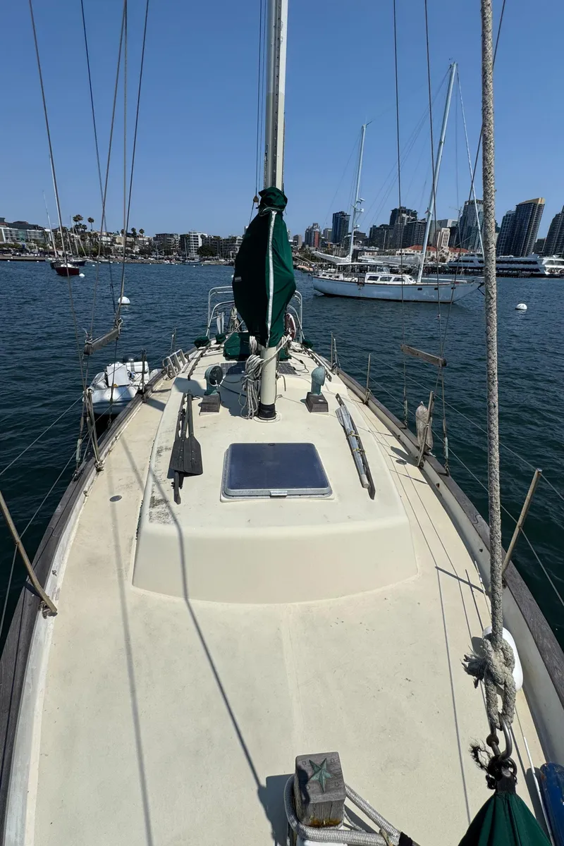 Slide: The Image of Sailboat Bluewater Ingrid 38, 1985 model, docked in a marina with city skyline background. - 9