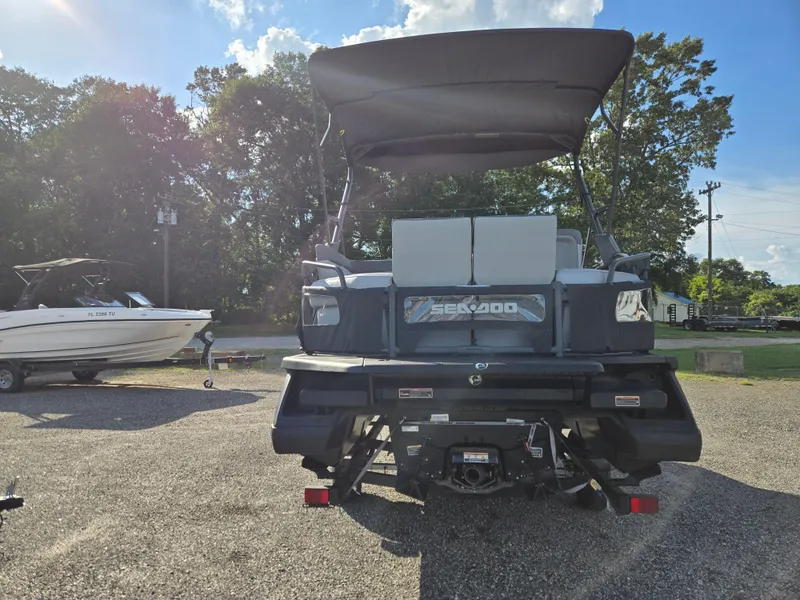 Slide: The Image of 2023 Sea-Doo Switch Cruise 18 pontoon boat parked outdoors, rear view. - 15