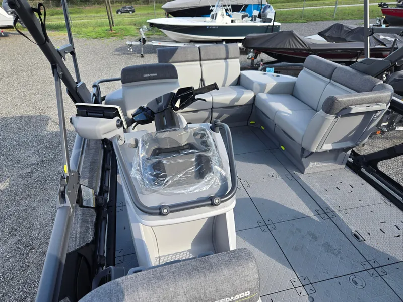 Slide: The Image of 2023 Sea-Doo Switch Cruise 18 interior with seating and control console, parked outdoors. - 7