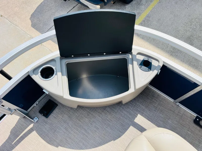 Slide: The Image of 2023 Sun Tracker Bass Buggy 18 DLX storage compartment with cup holders on a boat deck. - 13