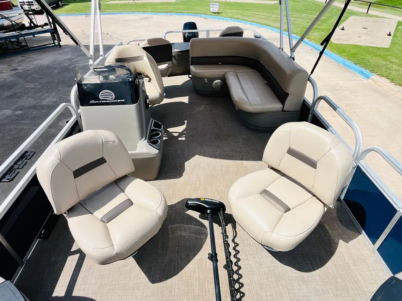 Slide: The Image of 2023 Sun Tracker Bass Buggy 18 DLX pontoon boat interior with beige seating and steering console. - 14