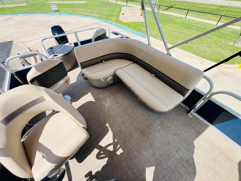 Slide: The Image of 2023 Sun Tracker Bass Buggy 18 DLX pontoon boat interior with beige seating and spacious layout. - 15