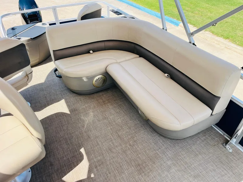 Slide: The Image of 2023 Sun Tracker Bass Buggy 18 DLX pontoon boat interior with beige seating and carpeted floor. - 16