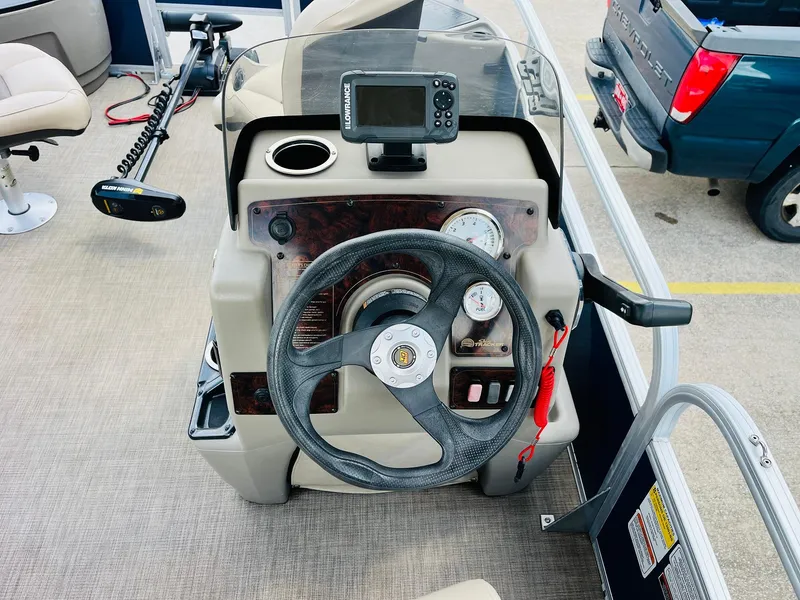 Slide: The Image of 2023 Sun Tracker Bass Buggy 18 DLX dashboard with steering wheel and control panel. - 20