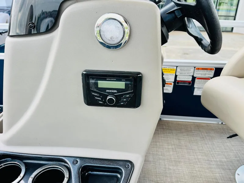 Slide: The Image of 2023 Sun Tracker Bass Buggy 18 DLX dashboard with Kicker stereo system and cup holders. - 22