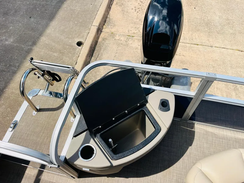 Slide: The Image of 2023 Sun Tracker Bass Buggy 18 DLX boat with open storage compartment and motor. - 26