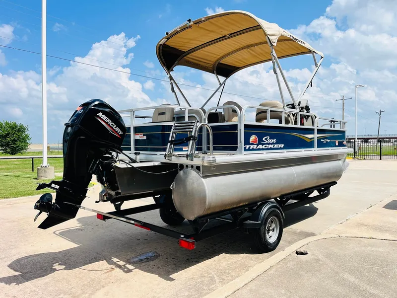 Slide: The Image of 2023 Sun Tracker Bass Buggy 18 DLX pontoon boat with Mercury outboard motor on trailer. - 4