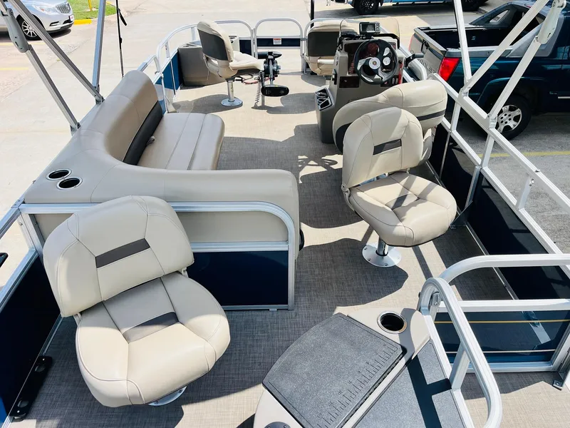 Slide: The Image of 2023 Sun Tracker Bass Buggy 18 DLX pontoon boat interior with beige seating and steering console. - 8