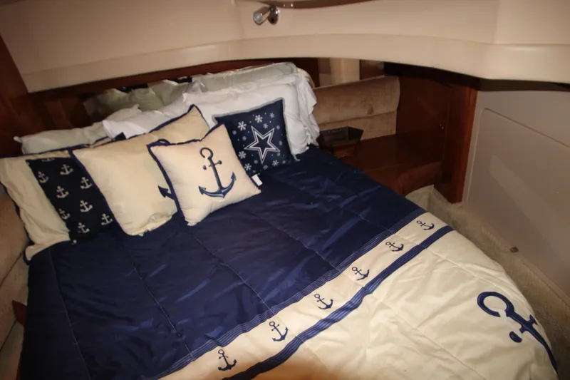 Slide: The Image of Luxurious 2007 Meridian 391 Sedan cabin with nautical-themed bedding and anchor pillows. - 26