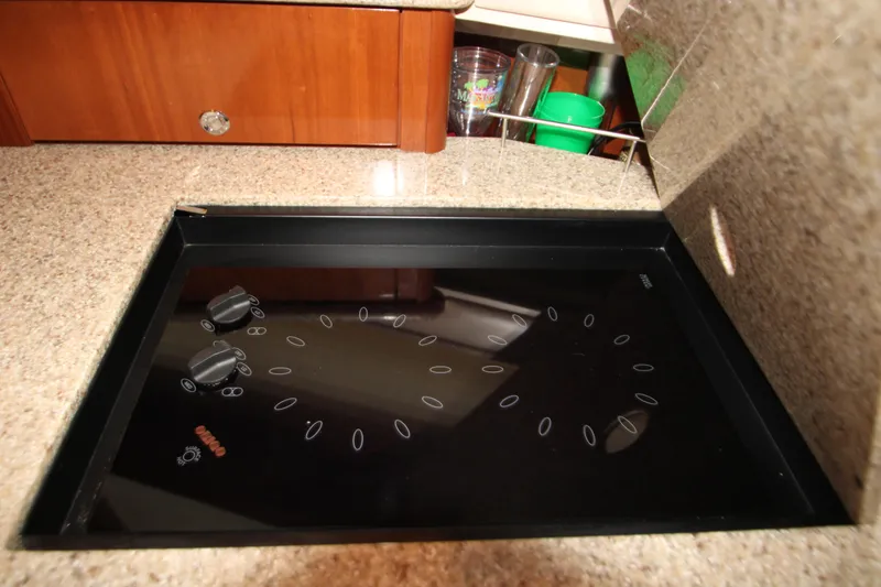 Slide: The Image of Stovetop in 2007 Meridian 391 Sedan yacht kitchen, featuring sleek black design. - 35