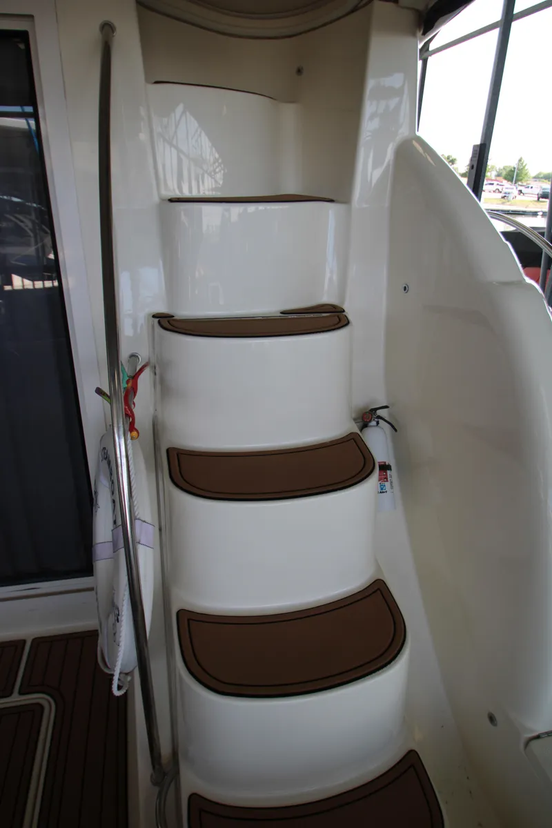 Slide: The Image of Staircase on a 2007 Meridian 391 Sedan yacht, featuring brown step mats and a metal handrail. - 39