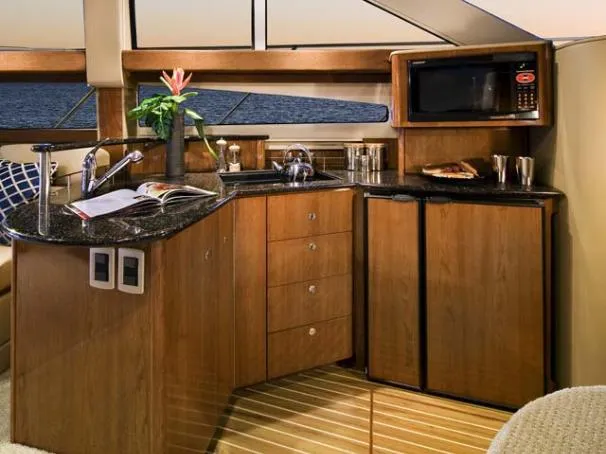Slide: The Image of Luxurious 2007 Meridian 391 Sedan yacht interior with kitchenette, featuring wood cabinetry and modern appliances. - 96
