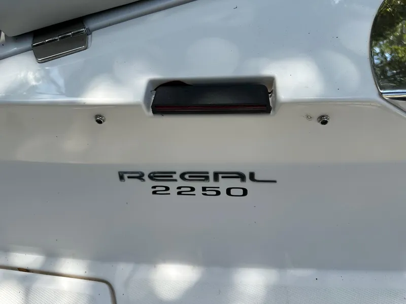Slide: The Image of 2008 Regal 2250 Cuddy boat emblem on white surface. - 11