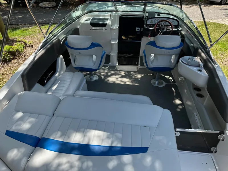 Slide: The Image of 2008 Regal 2250 Cuddy boat interior with white and blue seating, steering wheel, and dashboard. - 14