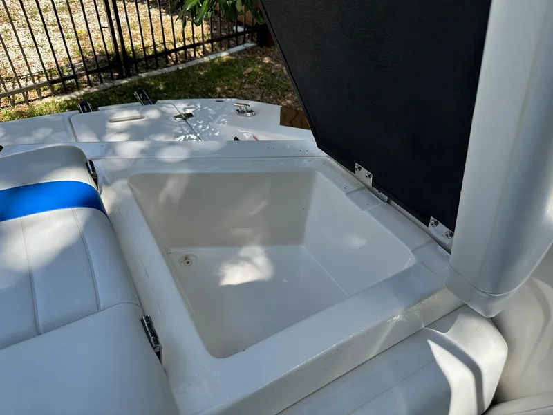 Slide: The Image of Open storage compartment on a 2008 Regal 2250 Cuddy boat, with seating and shadows. - 16