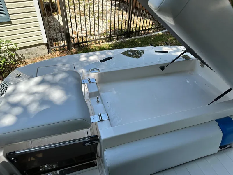 Slide: The Image of 2008 Regal 2250 Cuddy boat interior with open storage compartment and cushioned seating. - 17