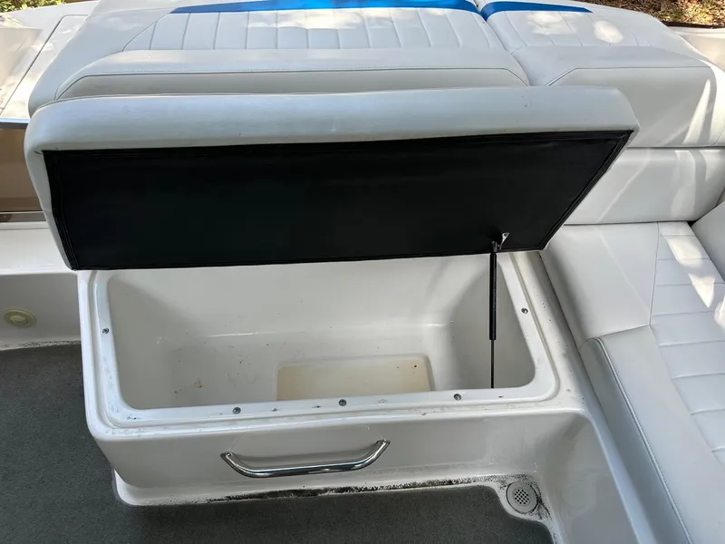 Slide: The Image of Open storage compartment on a 2008 Regal 2250 Cuddy boat with white seating. - 20