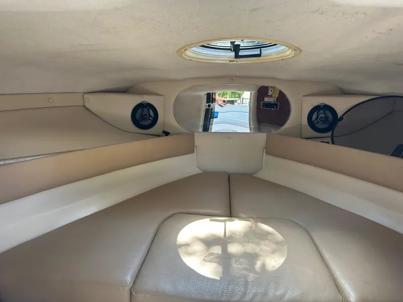 Slide: The Image of 2008 Regal 2250 Cuddy cabin interior with beige seating and round window. - 35