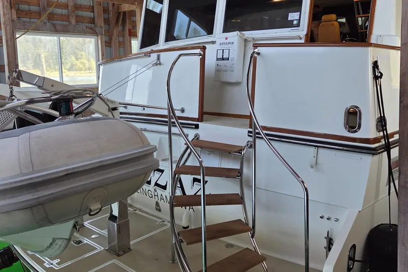 Slide: The Image of 1985 Chris-Craft 500 Constellation Motor Yacht with wooden steps and inflatable boat in a boathouse. - 10