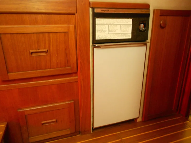 Slide: The Image of Wooden cabinetry and compact fridge in 1985 Chris-Craft 500 Constellation Motor Yacht interior. - 28