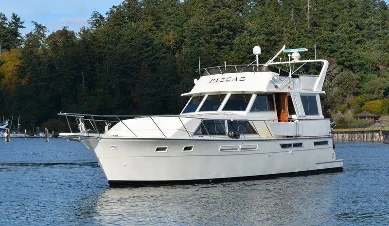 Slide: The Image of 1985 Chris-Craft 500 Constellation Motor Yacht cruising on a serene lake with forested backdrop. - 3