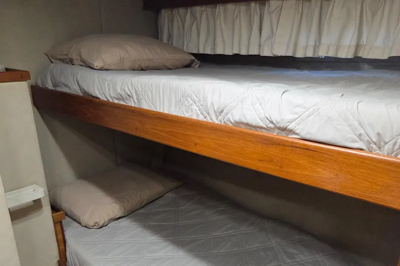 Slide: The Image of Bunk beds in 1985 Chris-Craft 500 Constellation Motor Yacht cabin, featuring wooden frames and white bedding. - 31