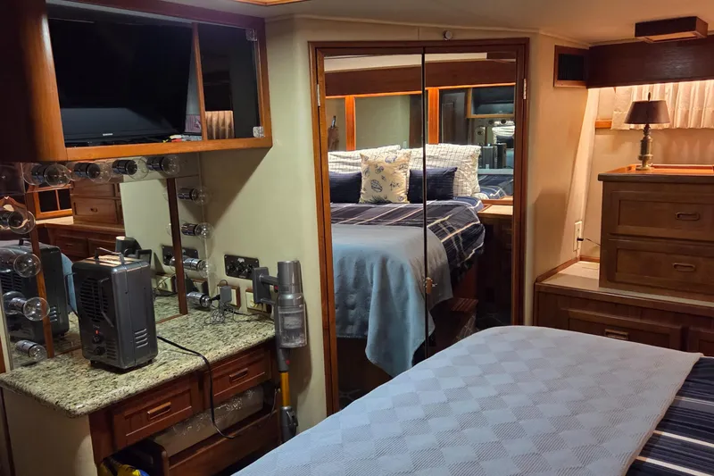 Slide: The Image of Interior of 1985 Chris-Craft 500 Constellation Motor Yacht, featuring cozy bedroom and vanity area. - 40