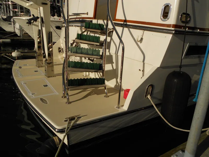 Slide: The Image of 1985 Chris-Craft 500 Constellation Motor Yacht stern with steps and docked at marina. - 5