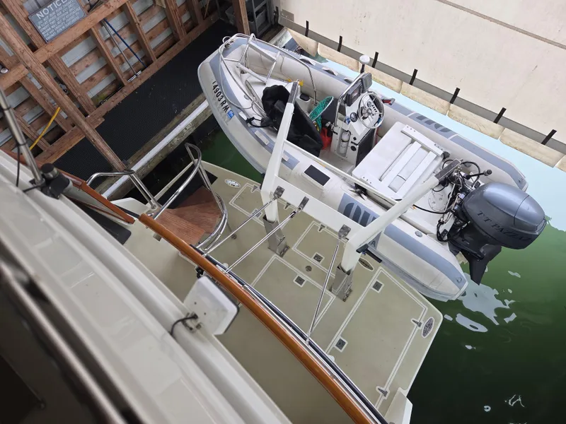 Slide: The Image of 1985 Chris-Craft 500 Constellation Motor Yacht with dinghy in dock. - 6