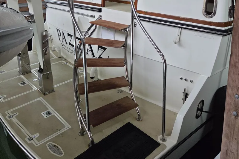 Slide: The Image of Staircase on 1985 Chris-Craft 500 Constellation Motor Yacht deck, featuring wooden steps and metal railings. - 8