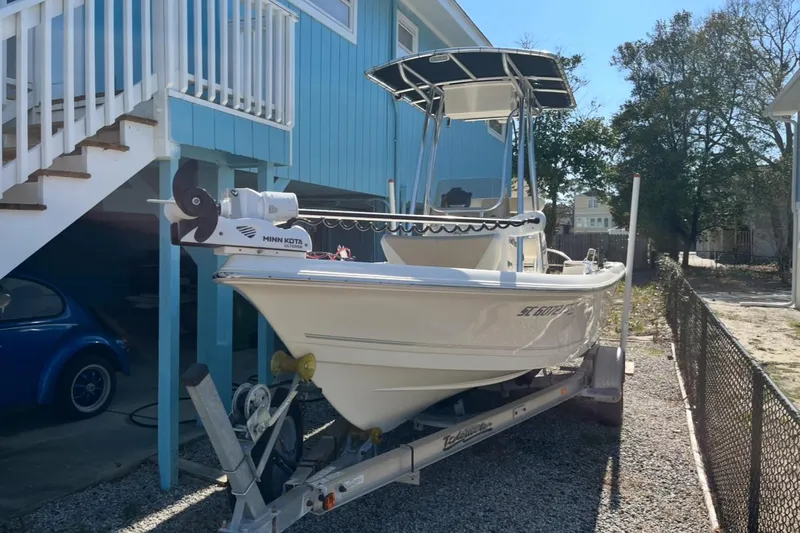 Slide: The Image of 2020 Bulls Bay 2000 boat on trailer, parked beside a blue house. - 10