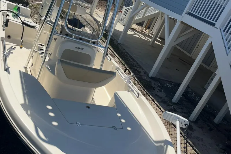 Slide: The Image of 2020 Bulls Bay 2000 boat with center console and seating, parked near a raised structure. - 11
