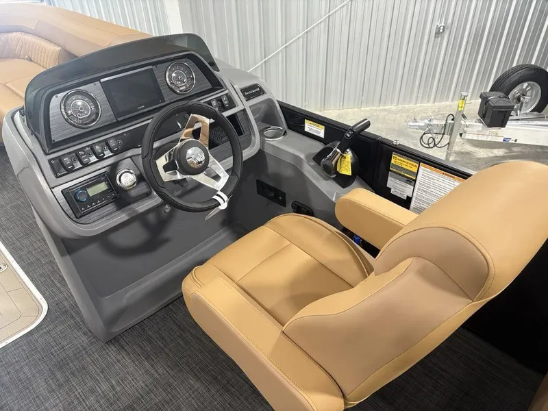 Slide: The Image of 2025 Godfrey Sweetwater 2286 SB boat helm with tan seating and modern dashboard controls. - 14