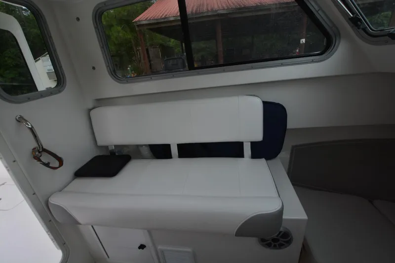 Slide: The Image of Interior of a 2025 Parker 2420 boat featuring a white cushioned bench seat. - 11