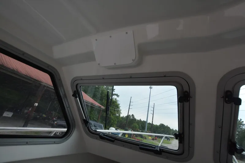 Slide: The Image of Interior view of Parker 2420 boat, showcasing windows and outdoor scenery, 2025 model. - 13