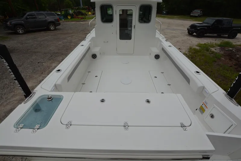 Slide: The Image of Parker 2420 boat, 2025 model, spacious deck, white finish, parked outdoors. - 19