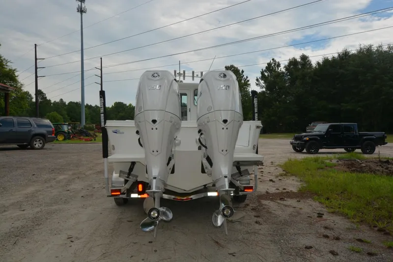 Slide: The Image of 2025 Parker 2420 boat with dual outboard motors in a parking area. - 3