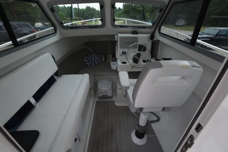 Slide: The Image of Interior of a 2025 Parker 2420 boat with seating and steering console. - 6