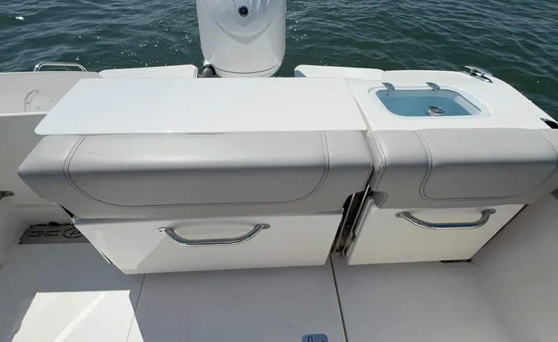 Slide: The Image of 2023 Pursuit DC 246 Dual Console boat interior with seating and sink. - 10