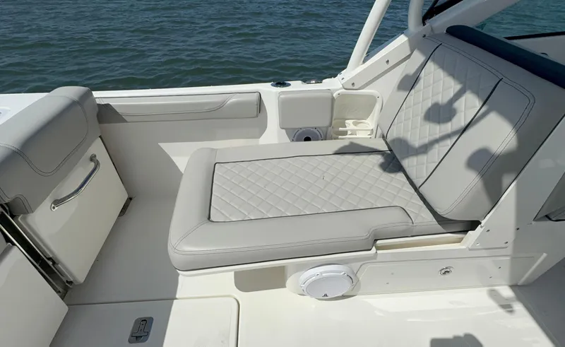 Slide: The Image of 2023 Pursuit DC 246 Dual Console boat interior with cushioned seating and ocean view. - 13
