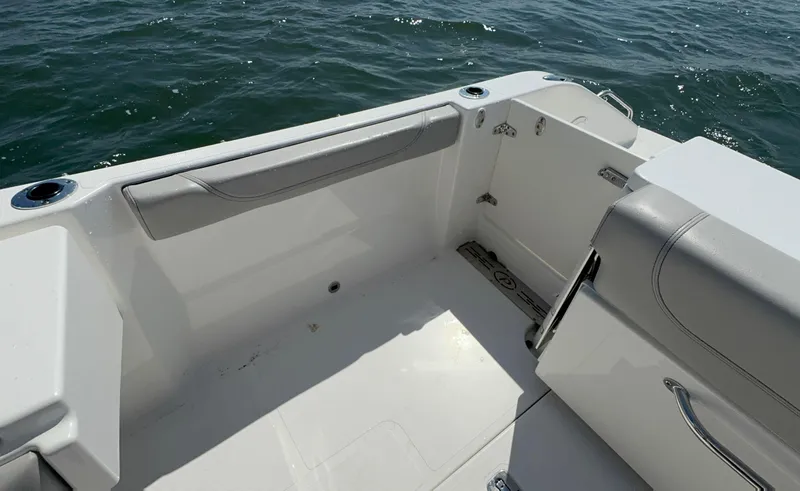 Slide: The Image of 2023 Pursuit DC 246 Dual Console boat interior with seating, on open water. - 14