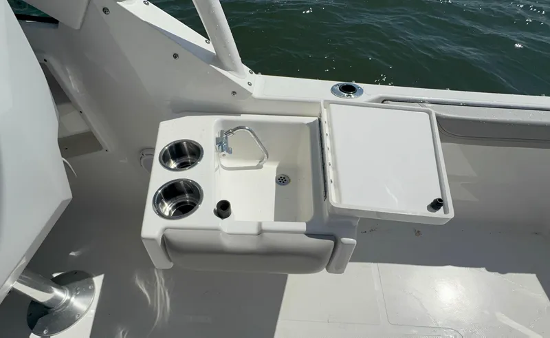 Slide: The Image of 2023 Pursuit DC 246 Dual Console boat sink and cup holders on deck. - 16