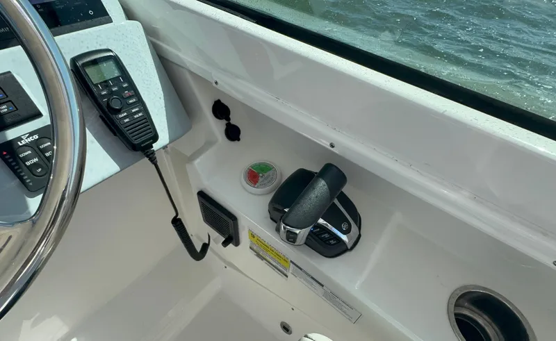 Slide: The Image of 2023 Pursuit DC 246 Dual Console boat controls with steering wheel and throttle. - 19
