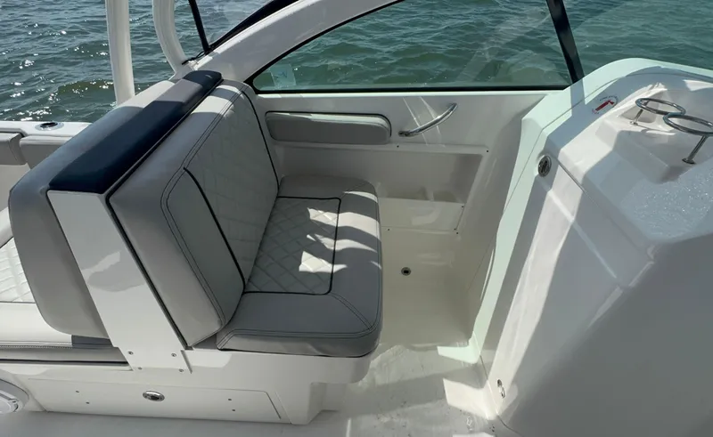 Slide: The Image of 2023 Pursuit DC 246 Dual Console interior with cushioned seating and ocean view. - 22
