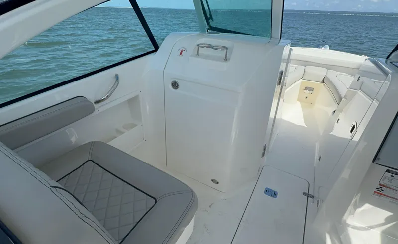 Slide: The Image of 2023 Pursuit DC 246 Dual Console boat interior with seating and ocean view. - 23