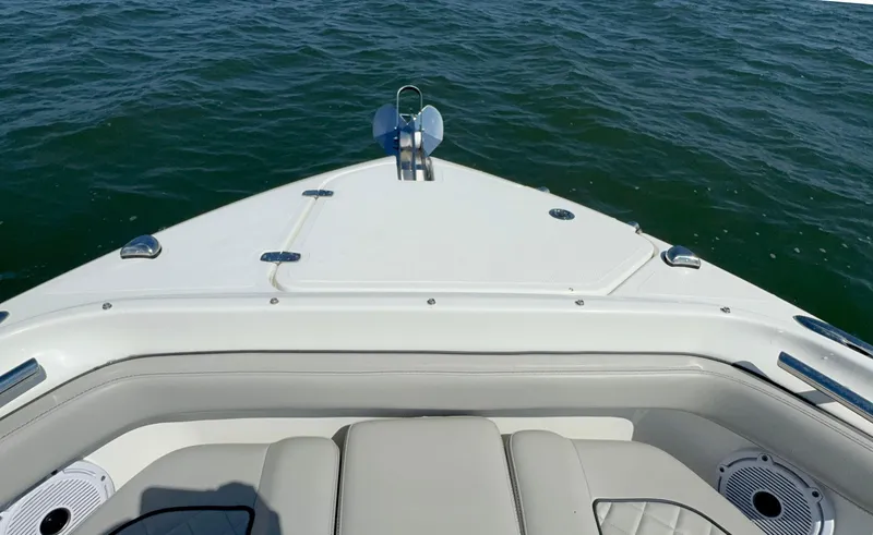 Slide: The Image of 2023 Pursuit DC 246 Dual Console boat on water, featuring sleek bow design. - 27