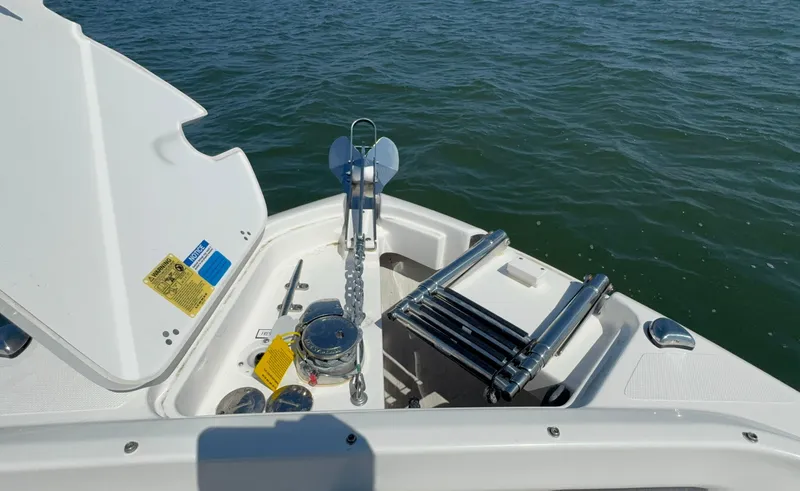 Slide: The Image of 2023 Pursuit DC 246 Dual Console boat anchor and ladder setup on water. - 28